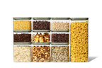 Naked Kitchen 20-piece glass countertop canister set with light green lids organizing dry goods like pasta, beans, oats and nuts