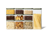 Naked Kitchen glass countertop set with green lids storing dry goods, with spaghetti in the tall canister