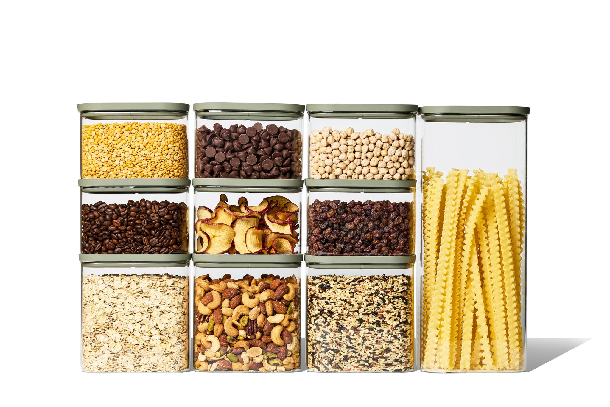 Full Naked Kitchen 20-piece glass countertop set with green lids holding pantry staples including pasta, grains, nuts and coffee