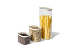 Naked Kitchen glass countertop canisters in three sizes storing coffee beans, grains and long pasta