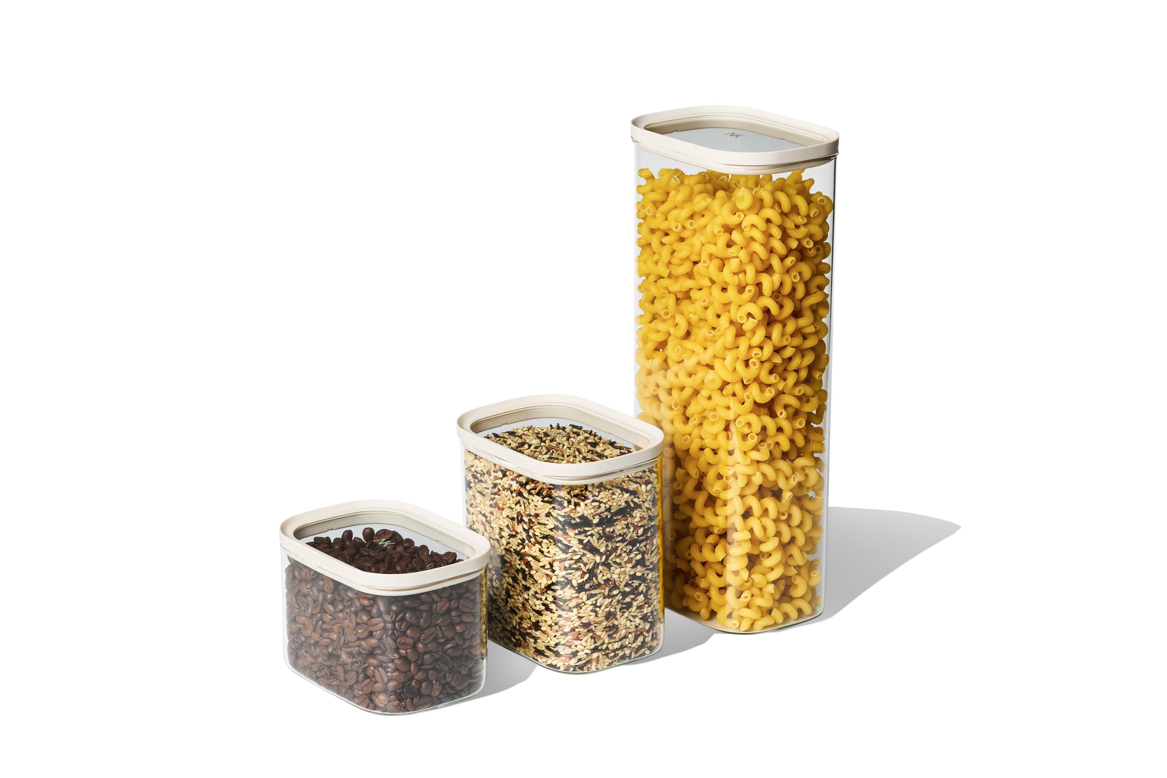 Three sizes of Naked Kitchen glass countertop canisters holding pasta, grains and coffee beans