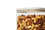 Close-up of a Naked Kitchen glass canister with airtight lid filled with mixed nuts