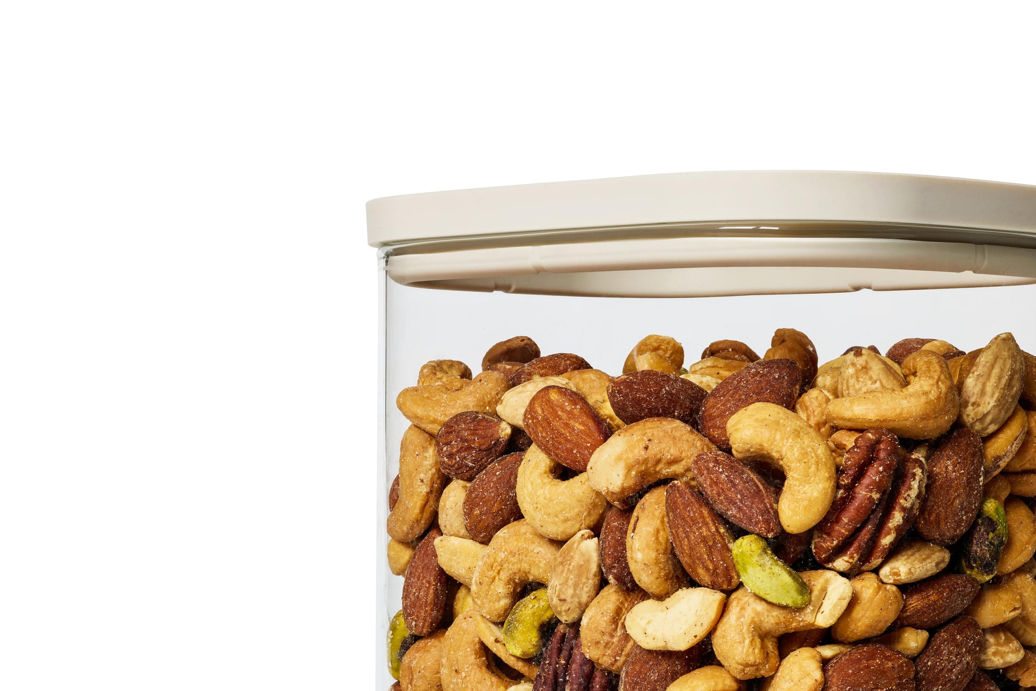 Close-up of a Naked Kitchen glass canister with airtight lid filled with mixed nuts