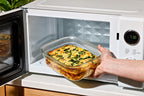 Person placing a dish of food into a microwave oven.