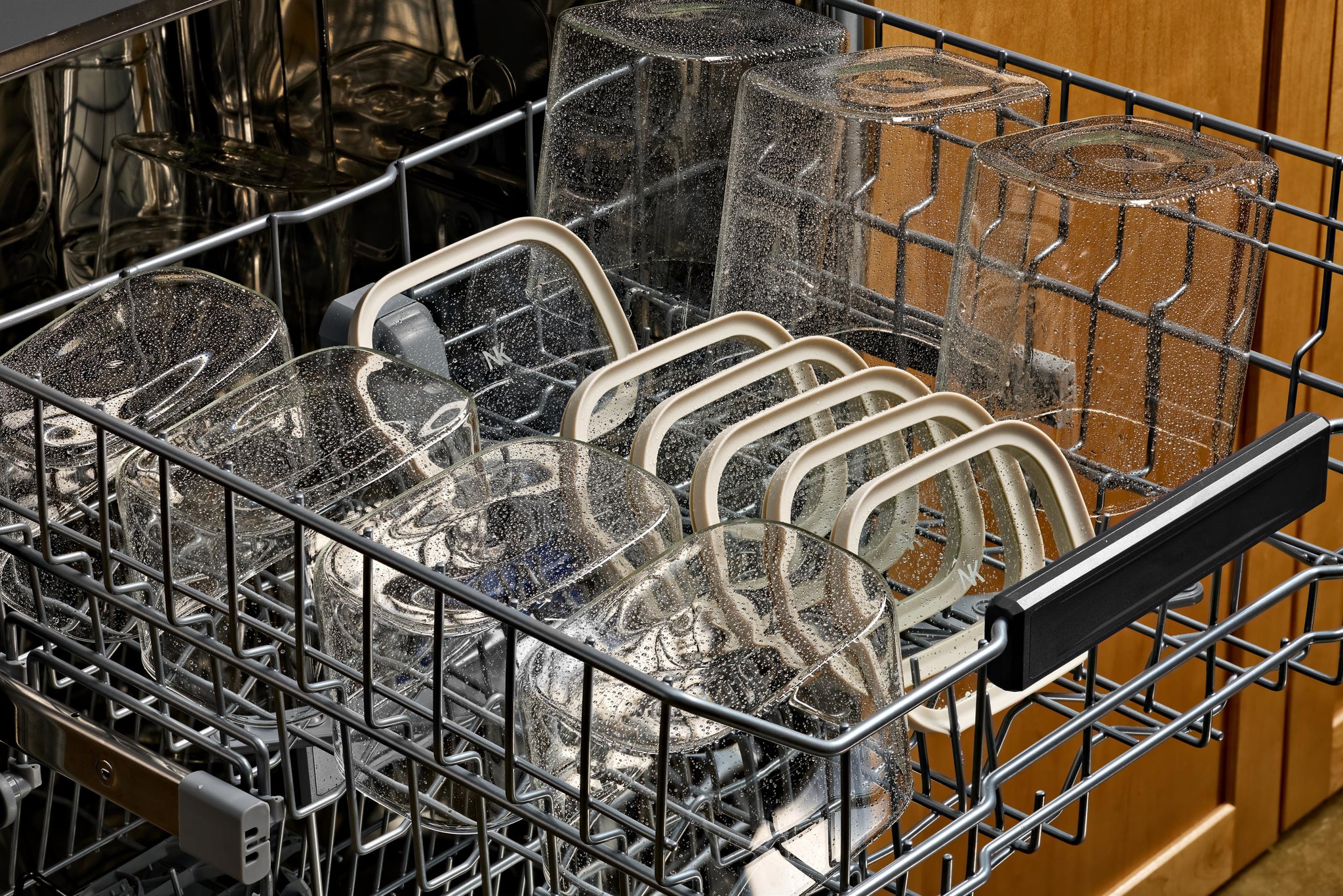 Dishwasher-safe Naked Kitchen glass containers and lids arranged in a dishwasher rack