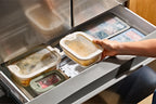 Person using a kitchen compost bin system with various compartments.
